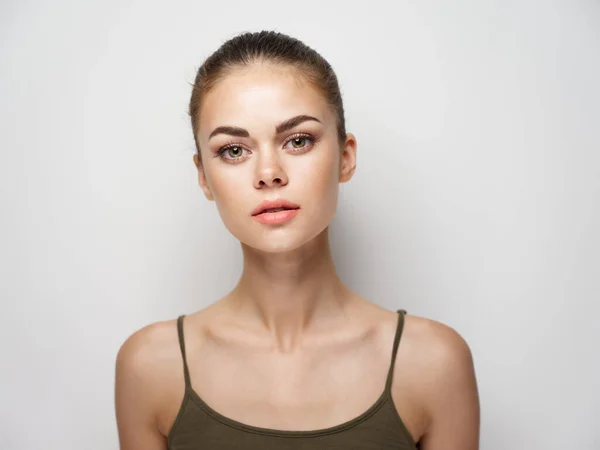 Portret van een vrouw t-shirt op een lichte achtergrond kapsel model naakte schouders — Stockfoto