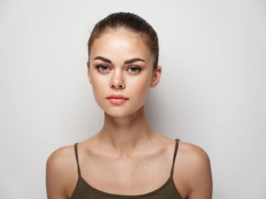 Açık arkaplanda bir kadın tişörtünün portresi.