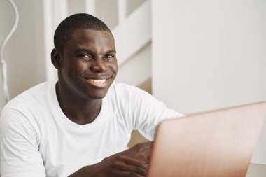 Afrikalı adam dizüstü bilgisayarda gülümsüyor İnternet iletişimi yaşam tarzı