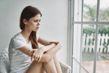 Kadın evde, pencere kenarındaki depresyonda yalnızlık tatminsizlik