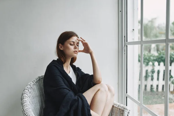 Женщина сидит в кресле рядом с зеркалом одиночества отдыха — стоковое фото