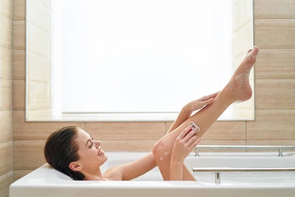 Mujer se encuentra en el cuarto de baño depilación cuidado de la piel limpia —  Fotos de Stock