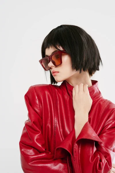 Aantrekkelijke vrouw dragen zonnebril rood jasje mode luxe studio — Stockfoto