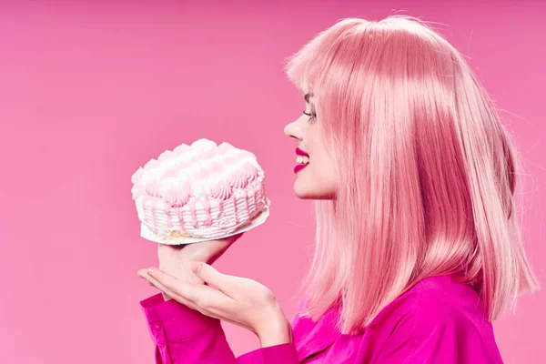 Woman with pink hair cake in hands sweets enjoyment isolated background — 스톡 사진