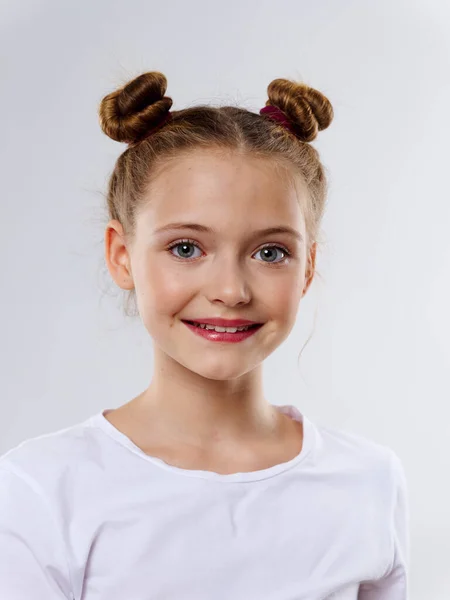 Szczęśliwa dziewczyna z modnej fryzury bułka na głowie biały t-shirt portret przycięty widok — Zdjęcie stockowe