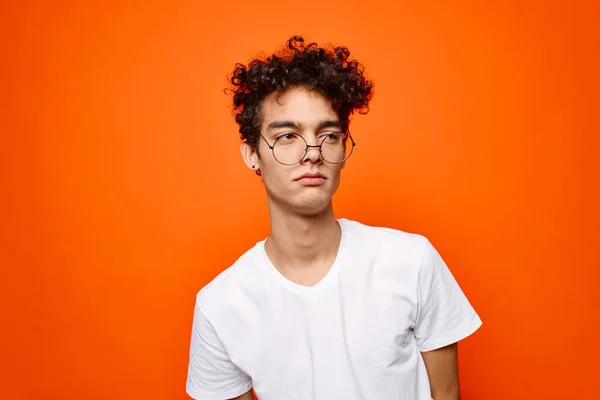 Alegre chico rizado pelo gafas moda naranja fondo —  Fotos de Stock