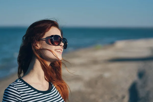 Kobieta w okularach i w paski T-shirt o zachodzie słońca lub tam w pobliżu morza widok z balkonu — Zdjęcie stockowe