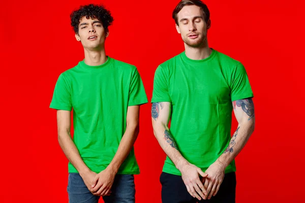 Due uomini in t-shirt verde tre squadre emozioni divertimento — Foto Stock