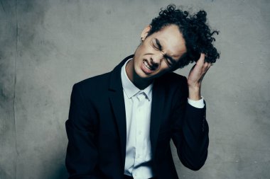 Kıvırcık saçlı ceketli adam modern moda işi yapıyor.