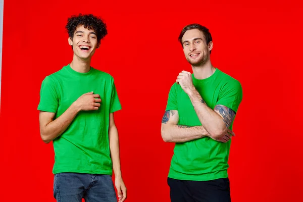Amici allegri Verde t-shirt comunicazione emozioni rosso sfondo — Foto Stock