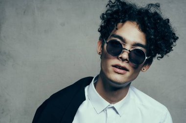 Yakından bakınca gözlüklü ve gömlekli yakışıklı bir manken.