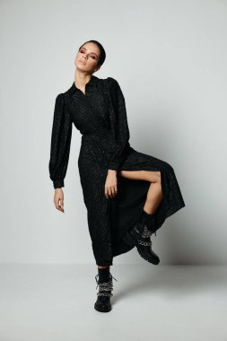 Kapalı gözlü güzel bir kadın. Parlak makyajlı. Siyah elbise stüdyosu.