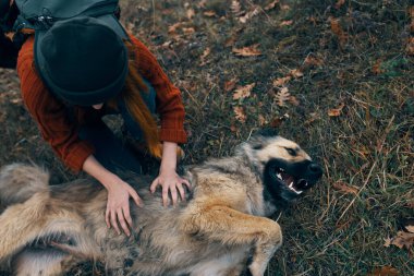Köpeğin yanındaki sırt çantalı turist eğleniyor.