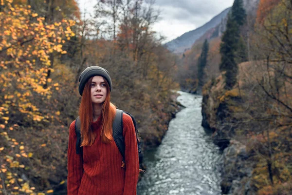 Vrouw wandelaar met rugzak in de bergen herfst bos rivier landschap — Stockfoto
