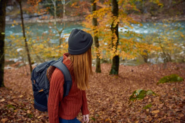 Femme avec sac à dos voyage tourisme forêt paysage parc rivière tombé feuilles vue latérale — Photo