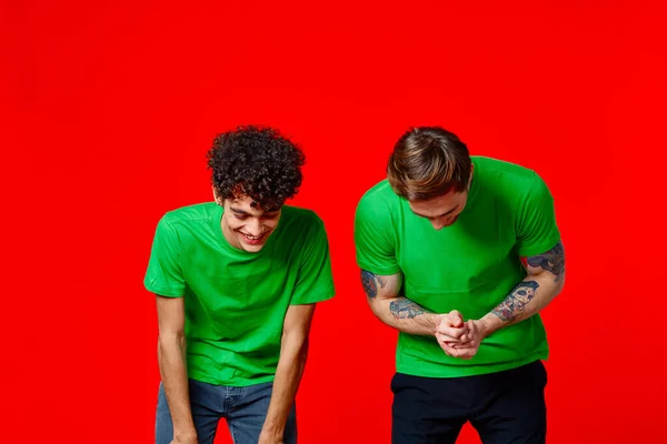 Due amici allegri in magliette verdi gioia di comunicazione — Foto Stock