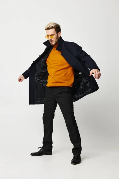 Hombre en abrigo desabotonado suéter naranja pantalones y botas — Foto de Stock