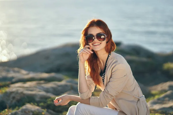 Mulher em óculos de sol e calças de camisola rosa Rock of the sea ocean — Fotografia de Stock