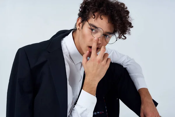 handsome guy in a jacket and shirt and glasses In a bright room photo studio model hairstyle curly hair
