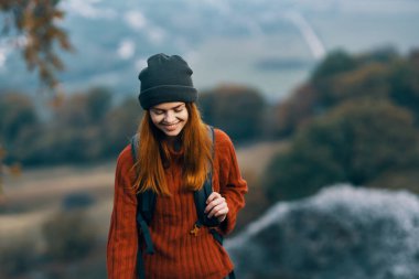 Dağlarda şapkalı bir kadın yürüyüşçü. Tatil macerası.