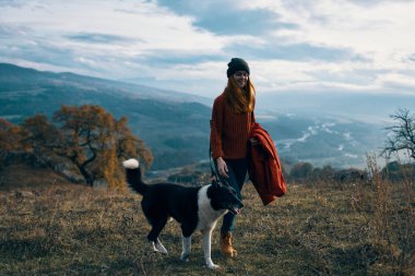 Kadınlar doğada köpeğin yanında yürürken dağlar seyahat eder.