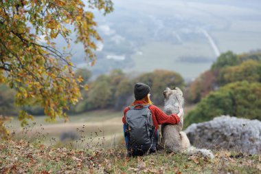 Dağlarda köpek dostluğu olan bir kadın doğa manzarası.