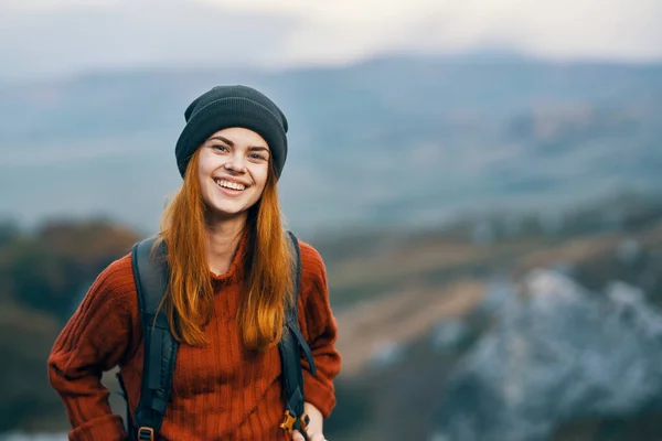 여행 가방을 들고 웃으며 산을 걸어다니는 여자 — 스톡 사진