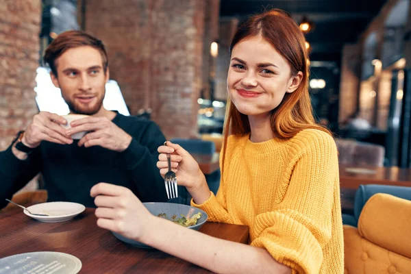 Homens e mulheres emocionais em uma mesa em um café divertido casal salada refeição — Fotografia de Stock