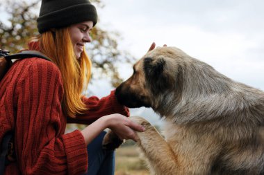 Neşeli kadın turist köpek doğasıyla oynuyor. Temiz hava.