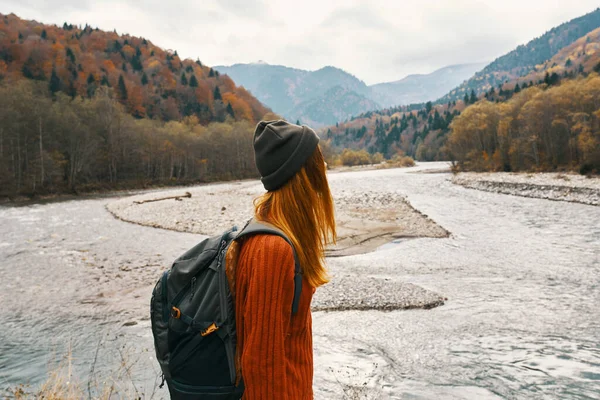 Viajante bonito com uma mochila perto do rio nas montanhas na paisagem da natureza — Fotografia de Stock