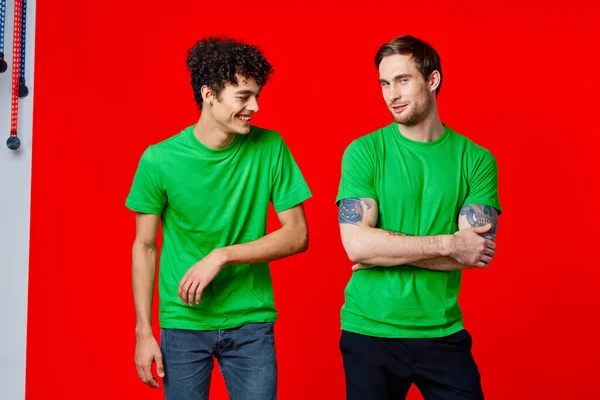 Два чоловіки в зелених футболках сміються спілкування радість — стокове фото