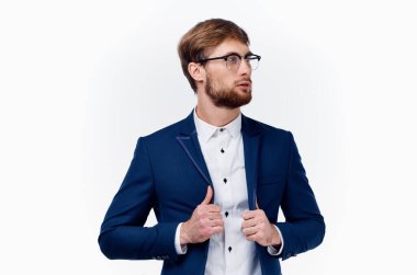 Klasik takım elbiseli sarışın adam ceketinin kollarını kırpıştırıyor.