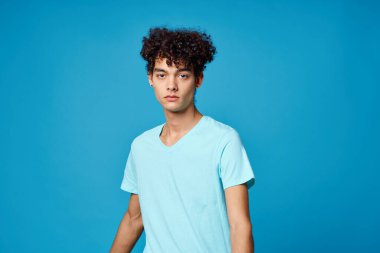 Kıvırcık saçlı, mavi tişörtlü adam...