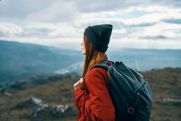 Mulher casaco chapéus olhando para a montanha na distância nuvens céu azul Modelo mochila — Fotografia de Stock