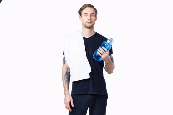 Chlap s lahví fitness a ručníkem na rameni — Stock fotografie