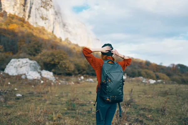 Femme avec un sac à dos marche sur la nature dans les montagnes en automne ciel bleu rochers paysage — Photo