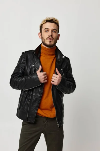 Emotionele man in een oranje trui trekt zijn jasje recht en kijkt vooruit — Stockfoto