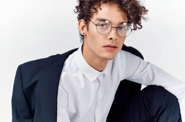 Portrét kudrnatého chlapa v košili v bundě a brýlích na světlém pozadí zblízka — Stock fotografie