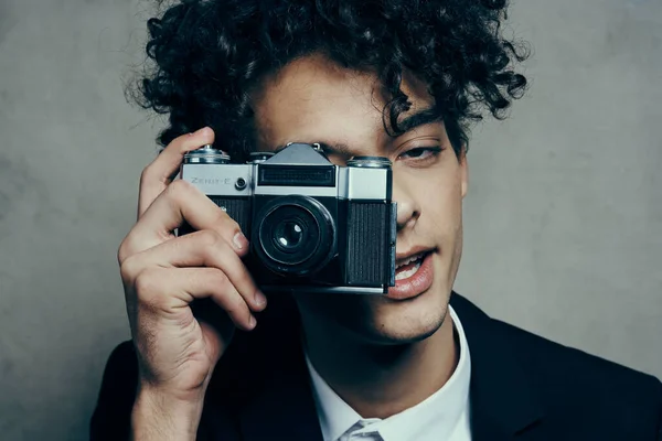Kinky kille med en kamera i handen svart jacka vit skjorta hobby kul — Stockfoto