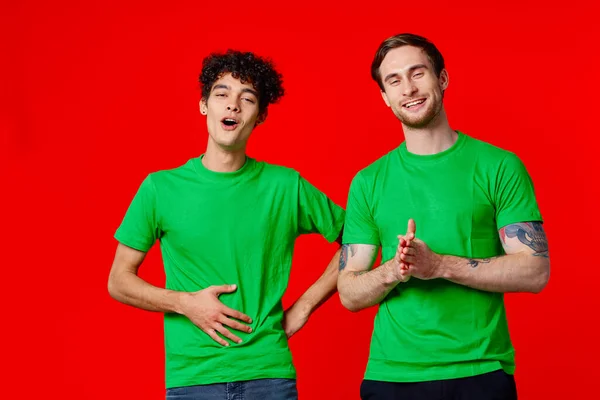 Zwei Freunde grüne T-Shirts Emotionen Kommunikation Freude — Stockfoto