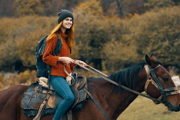 Cheerful woman hiker riding a horse adventure mountains fresh air — Stock Photo, Image