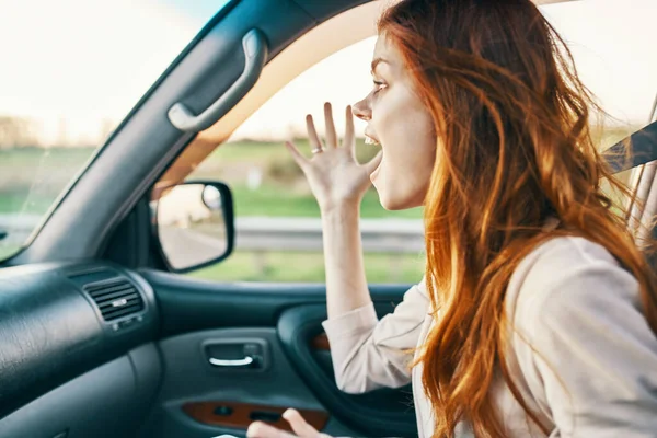 Mujer emocional sentada en el asiento delantero en un modelo de emociones salón de coches — Foto de Stock