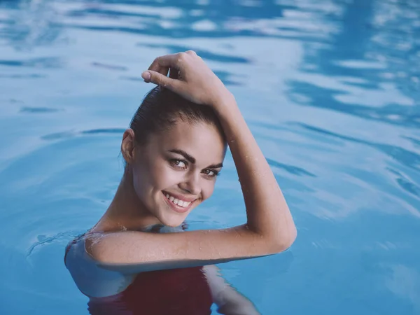 Веселая женщина в красном купальнике в руке бассейна на голове — стоковое фото