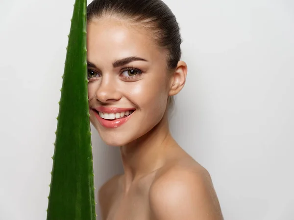 Sorrindo mulher com folha de aloés verde no fundo luz corte vista closeup retrato — Fotografia de Stock