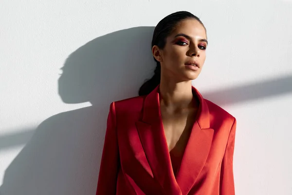 Una señora con una chaqueta roja apoyada en las paredes de luz del local — Foto de Stock