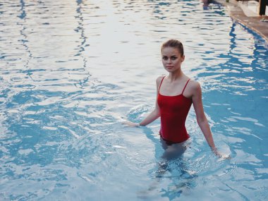 Havuzda yüzen seksi kadın dinleniyor.