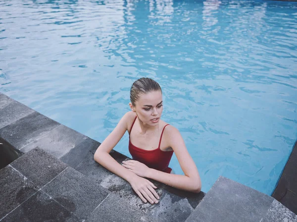 Женщина в купальнике опирается на плитку бассейна сверху вид на чистую воду пейзаж — стоковое фото