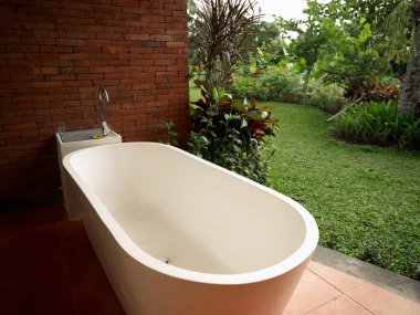 Kahverengi fayanslar üzerinde beyaz banyo. Arka planda doğa.