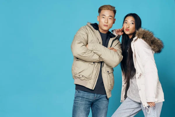 Молода пара азіатської зовнішності в зимовому одязі модний синій фон — стокове фото