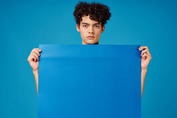 곱슬곱슬 한 파란색 양귀비 포스터 광고를 내는 남자 — 스톡 사진